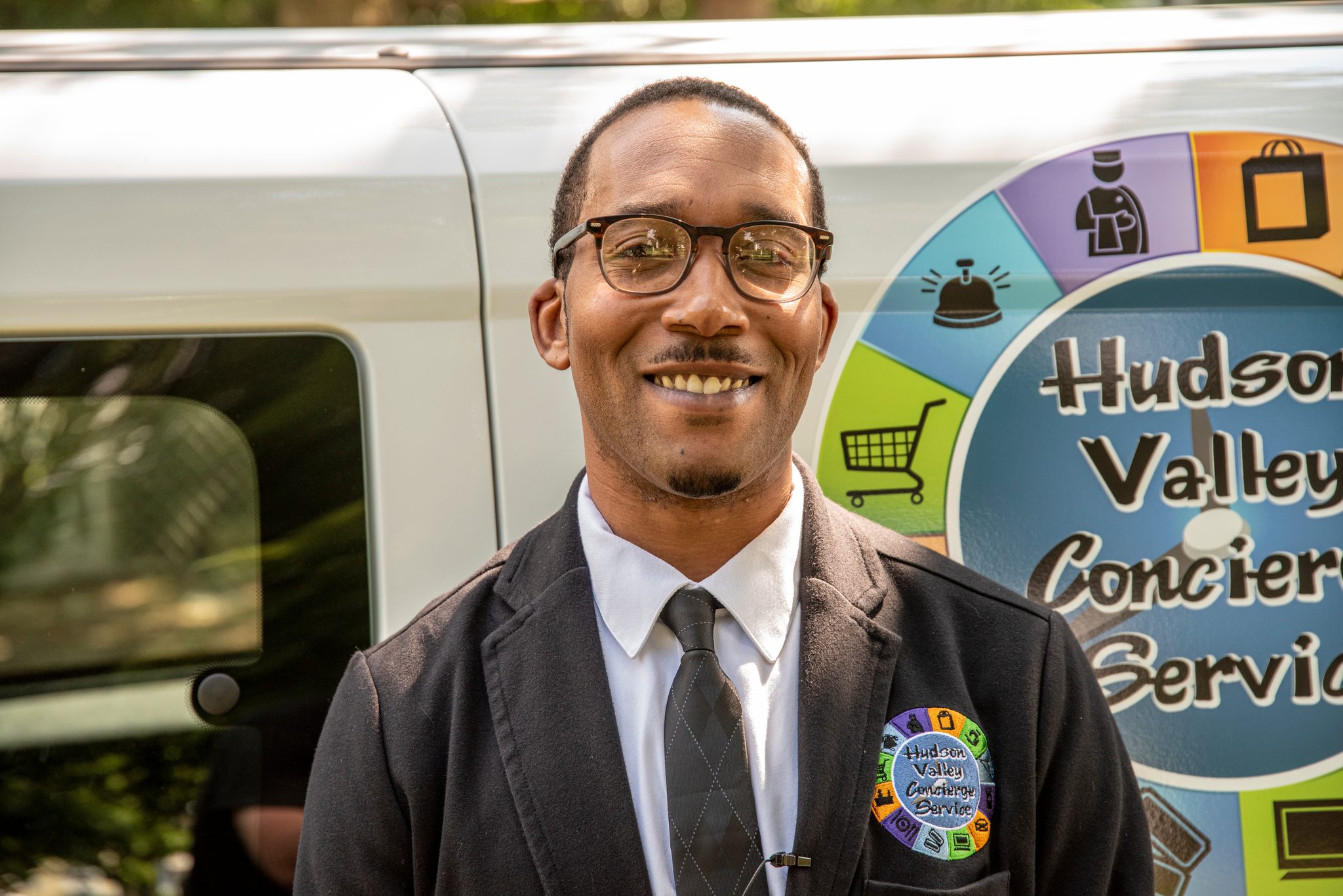Suit, tie and the van behind him with his business on the side.