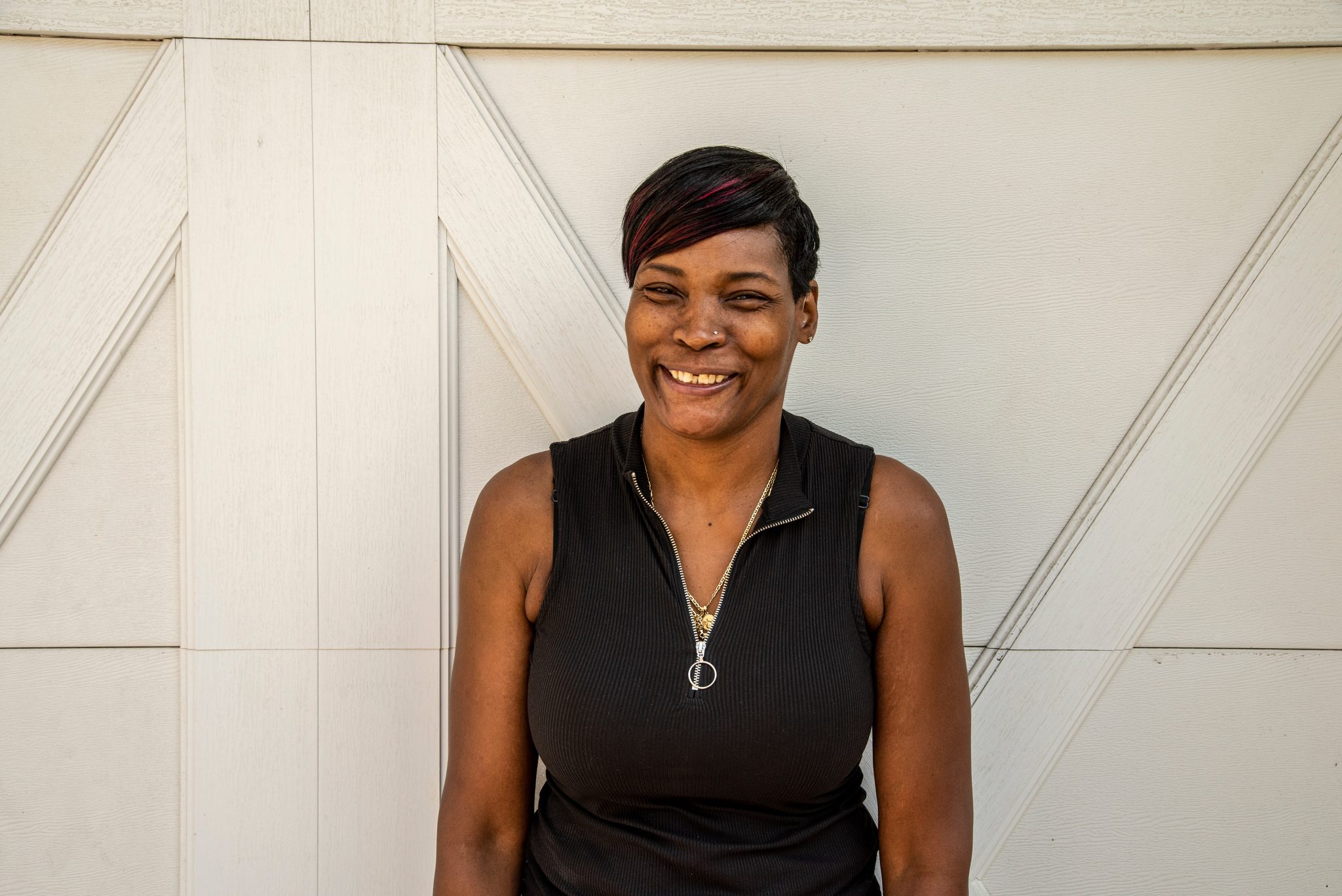 A wide smile against a white barn door.